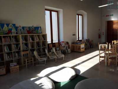 Poi � la volta dell'accogliente stanza allestita per i pi� piccoli: enormi cuscini bianchi, piccoli tavolini in legno...